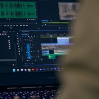 技术编辑在电脑前检查输入法隐私设置界面，屏幕上是权限开关列表，室内灯光偏冷